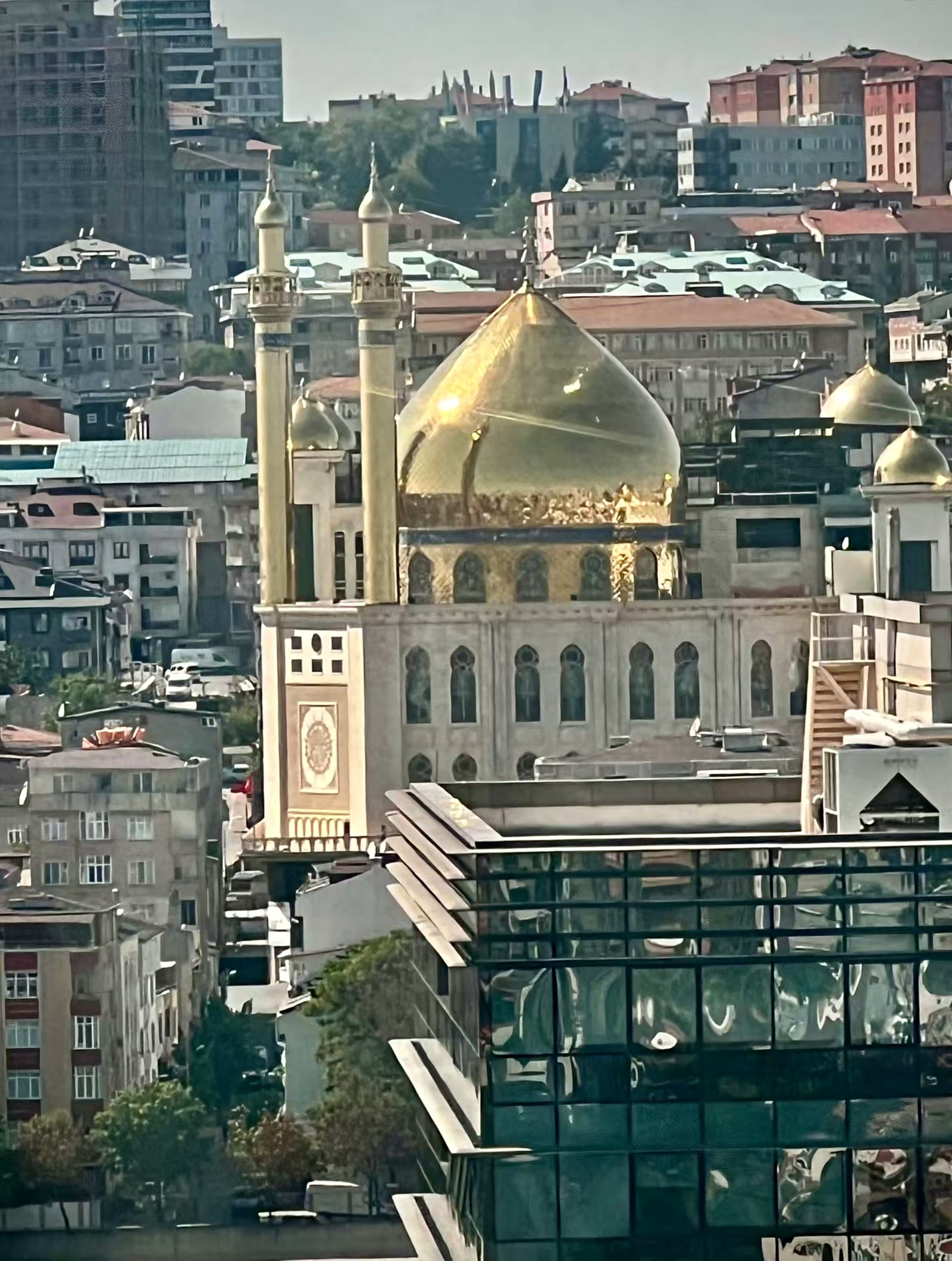 这个从我们入住酒店看到的少见的金顶清真寺：泽伊内比耶清真寺和文化中心(Zeynebiye Mosque and Cultural Center),它是作为什叶派（Caferi）社区的主要宗教和文化综合体，也是土耳其和欧洲什叶派穆斯林的重要中心。土耳其伊斯兰教徒占人口的绝大多数，其中大部分属于逊尼派。什叶派和逊尼派清真寺在风格上并无本质区别，因为清真寺的建筑风格主要受地域、文化和历史因素影响，而非教派本身；尽管如此，在部分什叶派聚集地区，可以看到对《伊玛目阿里圣陵》的模仿，例如其独特的尖塔和金色圆顶，而一些逊尼派清真寺则可能受到当地传统建筑风格的影响。