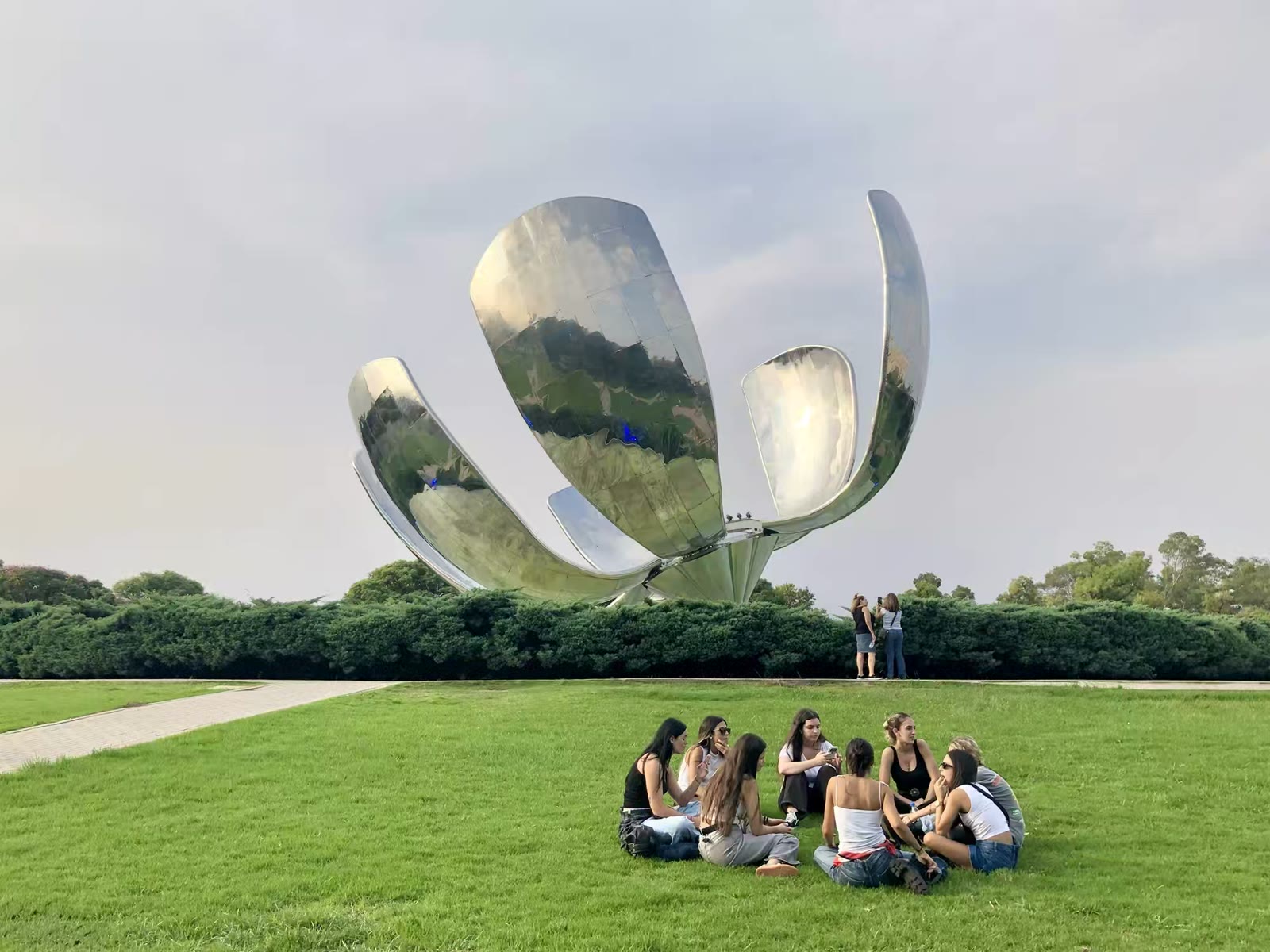 这座不锈钢花卉雕塑叫做 Floralis Genérica是阿根廷布宜诺斯艾利斯非常著名的地标性艺术品。它最引人注目的特点是其巨大的花瓣每天早晨随着日出而绽放，傍晚日落时分缓缓闭合，象征着希望的重生。