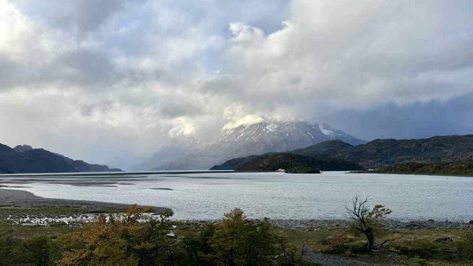 一路坑坑洼洼，颠颠簸簸，下午快六点才到格雷冰川湖。眼前整个百内群峰的最高点大百内峰（Paine Grande)被云雾覆盖着，它右边的百内角也被云雾遮住。