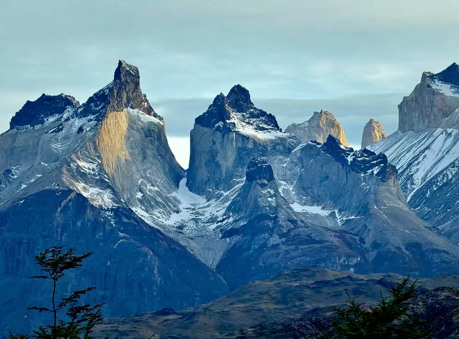百内角(Cuernos del Paine / Horns of Paine)那几座如同兽角般直指云霄的尖峰。它们有着非常独特的地质构造，呈现出截然不同的两层颜色——山体中下部是浅灰白色的花岗岩，而顶部则是深黑色的页岩。