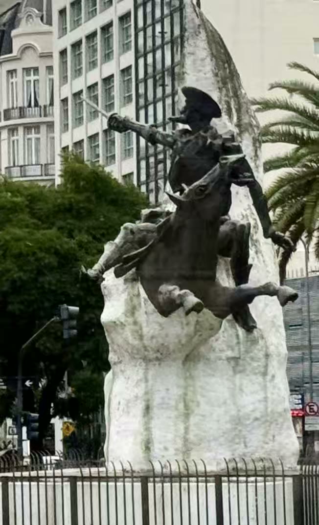 这座雕像被称为堂吉诃德纪念碑(Monumento al Quijote),位于阿根廷首都布宜诺斯艾利斯的七月九日大道(Avenida 9 de Julio)沿线。雕像背景与细节:• 创作者:由西班牙著名雕塑家奥雷利奥·特诺(Aurelio Teno)操刀制作。• 历史意义:这座雕像是西班牙在1980年赠送给阿根廷的礼物,专为纪念布宜诺斯艾利斯第二次建城(1580年)400周年而设立,并由当时的西班牙王后索菲亚亲自揭幕。这座融合了文学色彩与历史意义的雕塑,是布宜诺斯艾利斯市中心非常具有代表性的一处文化地标。